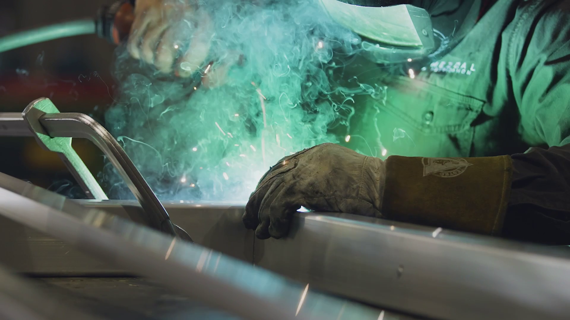 MIG welding an aluminium tray section with sparks and fume
